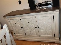 Full front view of the sideboard showing wood finish and decorative front doors.