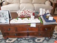 Front view of the wooden coffee table showing four small drawers with knobs and lower drawers in a dark wood finish with minor scratches.