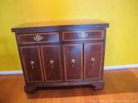 Front view of the Hickory buffet showing two drawers and four paneled doors with brass handles, highlighting the inlaid wood design.