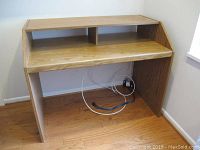 MDF computer desk showing front view revealing the main desktop surface and the integrated raised back shelf with some scratches on the surface.