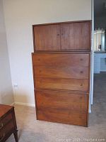Front view of the stacked wooden furniture units showing two drawer units and one cabinet on top.