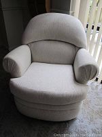 Front view of upholstered swivel chair showing rounded backrest, cushioned seat, and armrests.