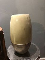 Front view of the tall ceramic vase showing smooth upper portion and textured lower portion.