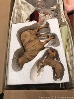 Two resin animal figurines (deer and fawn) lying in molded styrofoam packing inside the original box.