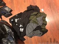 Three boys' long sleeve shirts on floor showing various colors and partial logos