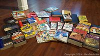 Overview of all books laid on wooden floor showing multiple titles from fantasy, adventure, comics, and reference genres.