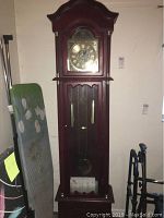 Full view of the grandfather clock showing overall height and condition.