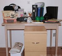Overview photo of office lot on wooden table including speakers, lamp, folders, file cabinet, shredder, and other office supplies.