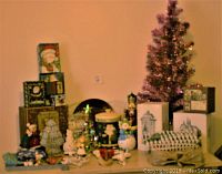Full view of vintage and contemporary Christmas lot with pink tinsel tree, assorted figurines, cookie jar, gift boxes and decorative items.