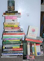 Photo showing a variety of books stacked including gardening, art, language, how-to guides, and fiction novels.