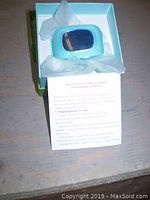Blue kids GPS tracking watch in open box with tissue paper, showing front of device