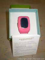 Pink kids GPS tracking watch in box with quick start guide visible.