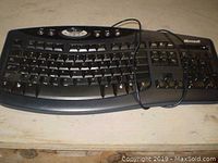 Front view showing full keyboard layout, multimedia keys, and wired connection