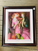 Image of framed decorative art print featuring a stylized couple, broad view showing frame and print detail.