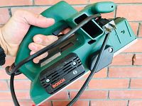Close-up photo of Bosch electric planer in green and black with power cord wrapped around handle