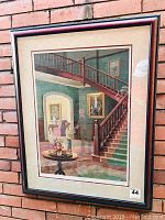 View of framed print showing interior scene with staircase, portraits, and two figures shaking hands.