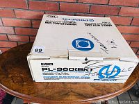 Original Pioneer box with model and branding visible, placed on wooden surface against brick wall.