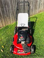 Full front view of mower showing deck, engine, handle and grass bag