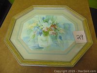 Framed watercolor flower painting in an octagon frame measuring 16 by 19 inches.