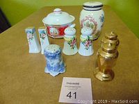 Overview of all items in the lot including Campbell Soup sugar bowl, floral jar, various salt and pepper shakers in different styles and materials.