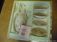 View of new Lenox porcelain oil bottle with stopper and four matching dishes in original box