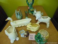 Photo of nine ceramic animal planters and figurines arranged on table.