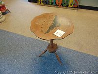 Wooden side table with visible eagle design on the top surface, showing scratches and wear