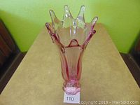 Front view showing the dusty rose colored flared vase with waved rim and rounded base