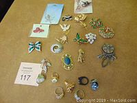 Full display of the assorted costume jewelry including rings and brooches on a flat surface.