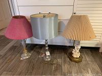 Three vintage lamps side by side showing details of each base and shade.