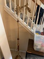 Full view of the vintage floor lamp showing its height and overall structure in front of a stairway.
