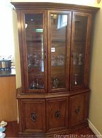 Front view of wood china cabinet with glass display doors and lower wooden storage cabinet doors with metal handles