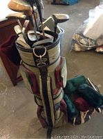 Golf bag standing upright filled with golf clubs in a storage room environment.