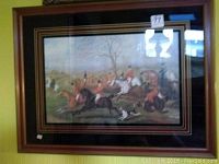 Full view of framed British hunting scene artwork showing multiple riders and hunting dogs, with visible seller tag on glass.