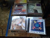 Albums are stacked and grouped showing some cover art including Mariah Carey and a compilation titled 'Proud to Be American'