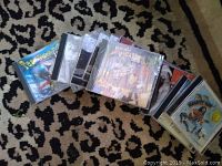 Various CD jewel cases laid out on patterned carpet showing album artworks for Stonewall, Manatee Man, and others.