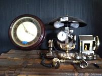 Front view of the combo clock, lamp, telephone reproduction showing clock face, lamp dome, handset, dial pad and house figurine element