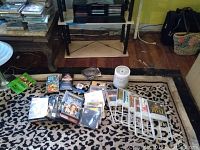Overview of DVDs, CDs, CDRs, VHS tapes, the shelf, and CD holder rack arranged on the floor and shelf.