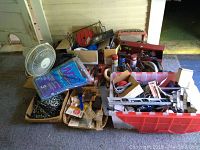 Wide view of assortment of tools, spray paint cans, chains, hardware, fan, boxes and containers.