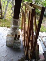 Wooden frames leaning against a surface with stacked clear textured glass blocks beside them