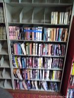 Front view of shelf with rows of VHS and Beta tapes arranged in compartments