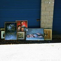 Framed artworks resting against a wall, showing variety of subjects and sizes from 20x15 inches up to 26x37 inches.