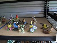 Wide view of all bird figurines displayed on shelf showing detailed colors and bases