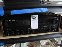 Front view of SAE Two A14 integrated amplifier on shelf with control knobs, meter display, and MaxSold tag.
