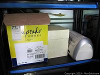 Overall view showing a yellow box (Cupcake Vineyards wine box) and a white container beside a Cricut machine.