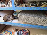 Shelf with sports collectibles including boxes, pins, and a binder with cards visible
