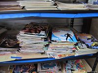 Shelves stacked with numerous vintage Marvel comic books in various conditions, showing spines and cover edges in a collection