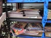 Two shelves densely packed with stacks of Marvel comics mostly in plastic sleeves.