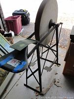 Front-left angle view of grind wheel showing stone, metal frame, seat and pedals