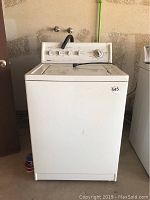 Front view of white Kenmore top loader washer with control panel and lid closed, showing item number sticker.
